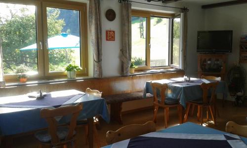 ein Esszimmer mit 2 Tischen und Fenstern in der Unterkunft Eggbauer in Sankt Anton an der Jessnitz