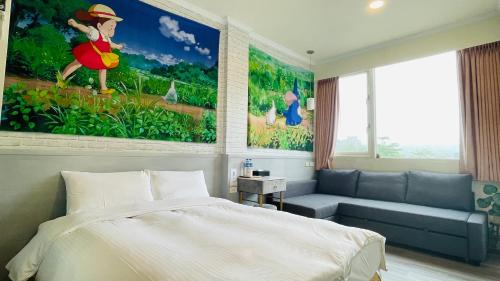 a bedroom with a bed and a couch and a painting at 星月小築 in Yuchi