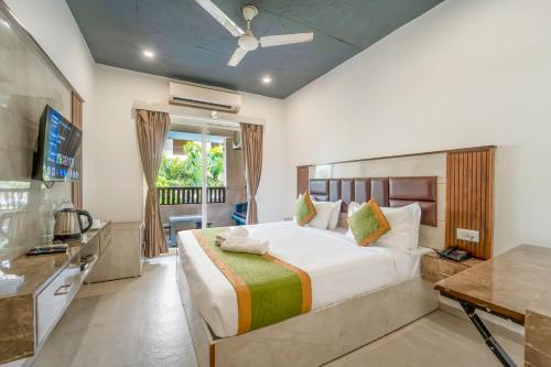a bedroom with a large bed and a television at Sia Signature Calangute in Calangute