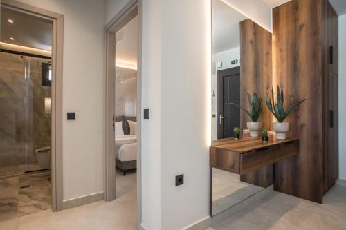 a hallway with a bathroom with a vanity and a bedroom at Celeste Luxury Villas in Lartos