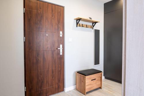 a closet with a wooden door and a stool at Apartament 16 in Sandomierz