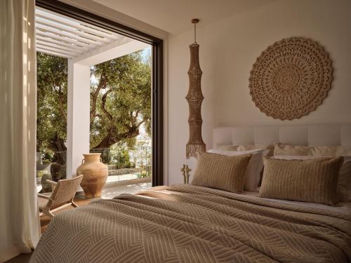 a bedroom with a large bed and a large window at PanoPlagia Villa in Agios Nikolaos