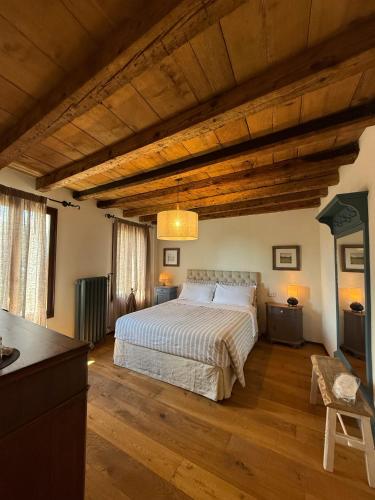 a bedroom with a large bed and wooden ceilings at B&b ANTICO MAGLIO in Asolo