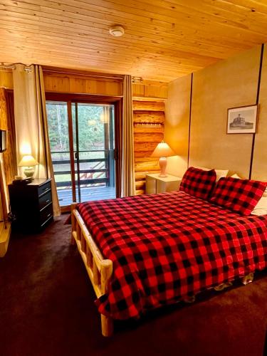 a bedroom with a red and black checkered bed at Anglemont Inn in Anglemont