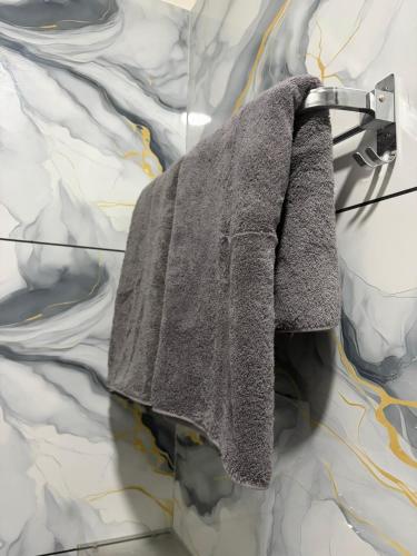 a grey coat hanging on a towel rack at Yatha sukham Prutham in Ujjain