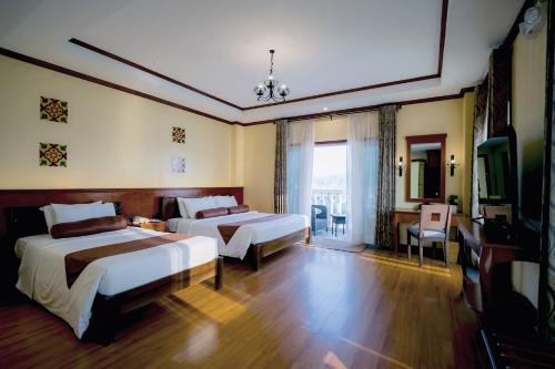 a hotel room with two beds and a television at Sunlight Hotel Coron in Coron