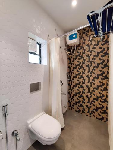 a bathroom with a toilet and a shower at Stay by Insata Hospitality - Kolkata in Kolkata