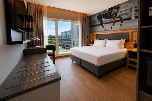 a hotel room with a bed and a desk at Radisson Red Funes in Rosario