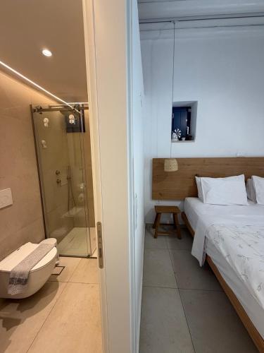 a bedroom with a shower and a bed and a tub at Armiriki Seaside in Kamares