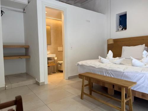 a white bedroom with a bed and a table at Armiriki Seaside in Kamares
