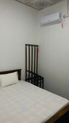 a bedroom with a white bed and a fan at JA Villa in Pottuvil