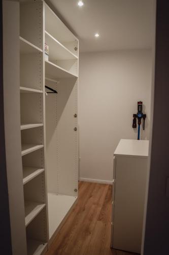 a closet with white shelves in a room at Apartment Claussen 1 in Bremerhaven