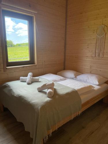 a bedroom with a large bed with towels on it at Domki Sudecka Przystań in Duszniki Zdrój