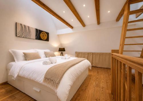 a bedroom with a large bed with white sheets at L'Atypique in Eguisheim