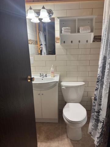 a bathroom with a white toilet and a sink at Anglemont Inn in Anglemont