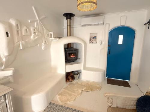 a white room with a blue door and a stove at Little Mykonos right here in Stanthorpe! in Stanthorpe