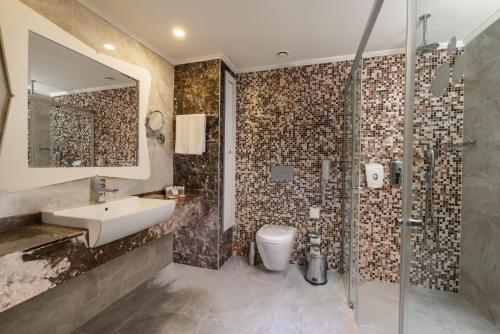 a bathroom with a sink and a shower and a toilet at Crystal Sunset Pearl Collection - Ultimate All Inclusive in Side