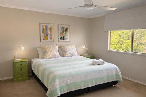 a bedroom with a bed with two lamps and a window at Grandview Holiday Beach House in Gracetown