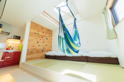 a room with a hammock hanging from a wall at Tomareru Himitsukichi L-Base in Matsumoto