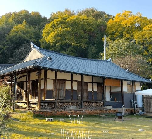 an old house with a black roof in a yard at Damyang Hwayang in Damyang