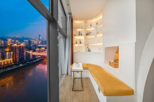a room with a window with a view of the city at ChongQing BackHome Riverview Hotel in Chongqing