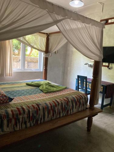 a bed with a canopy in a bedroom at Bali Bobo Hostel in Jimbaran