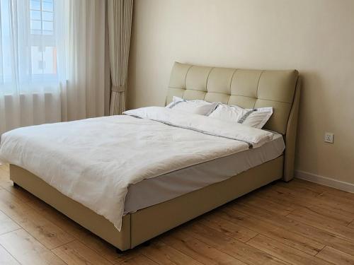 a bed with white sheets and pillows in a bedroom at "Private Room in New Luxury " Apartment in Ulaanbaatar