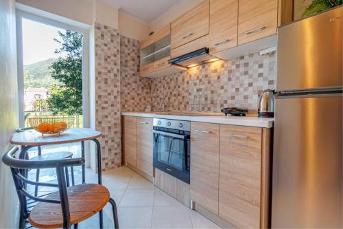a kitchen with a stainless steel refrigerator and a table at Ionelia Hospitality Apartments in Ipsos