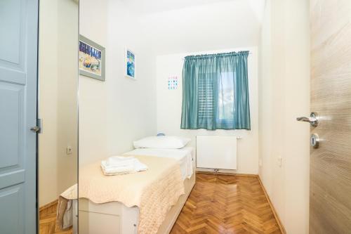 a white bathroom with a table and a window at D&J Apartments in Primošten