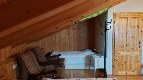 a room with a bed and two chairs at Pension Unterleiten in Ramsau