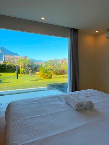 a bed in a bedroom with a large window at Volcano Bliss Villa Kintamani in Kintamani