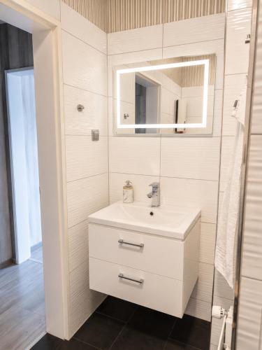 a white bathroom with a sink and a mirror at Luxsuite Studio Oberhausen Centro Bahnhof in Oberhausen
