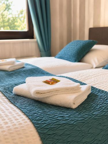 two white towels on a bed with a window at Luxsuite Studio Oberhausen Centro Bahnhof in Oberhausen