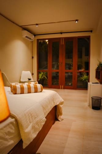 a bedroom with a bed and a large window at Mi Casa Coastal Villa in Akurala