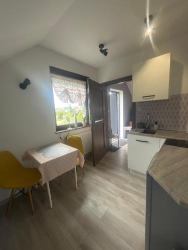a kitchen and dining room with a table and chairs at Apartament Teo -Rewal in Rewal