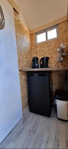 a small kitchen with a black dishwasher in a room at Tiny House auf der Kingswood Ranch in Cornberg