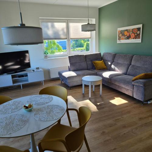 a living room with a couch and tables and chairs at Kastani Home 15 in Tartu