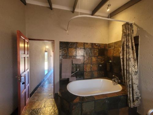a bathroom with a large tub in a room at Kunkura Game Lodge & Conference Centre in Modimolle