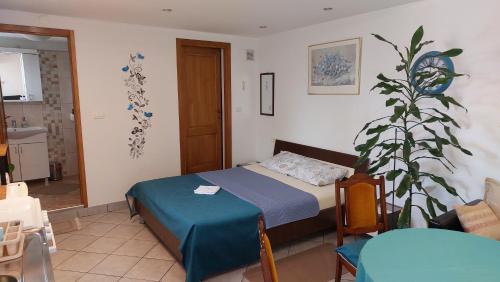 a bedroom with a bed and a plant in it at Apartment Panorama in Kotor