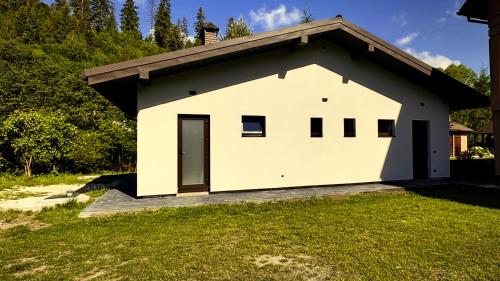 a white house with a roof at Котедж RIVERHILL 2-4 осіб in Slavske