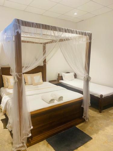 a bedroom with two beds with mosquito nets at Ceylon Kingsmen Garden - Katunayake Airport Transit Hotels in Negombo
