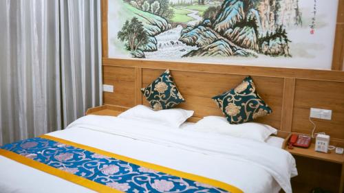 a bedroom with a bed with blue and white pillows at 八零年代客栈 in Hanqiyu