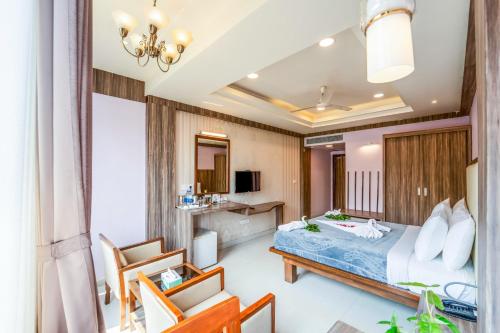 a hotel room with a bed and a chair at Panaji Residency in Panaji
