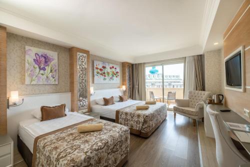 a hotel room with two beds and a television at Crystal Sunset Pearl Collection - Ultimate All Inclusive in Side