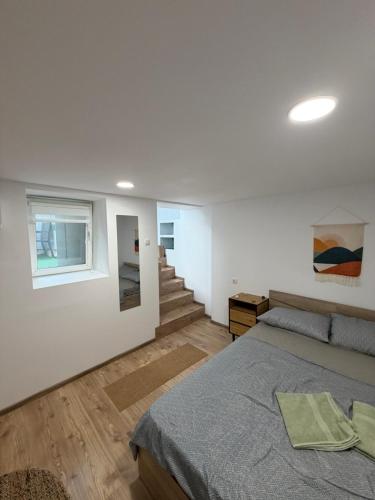 a white bedroom with a bed and a staircase at Boho style house Varna in Varna City