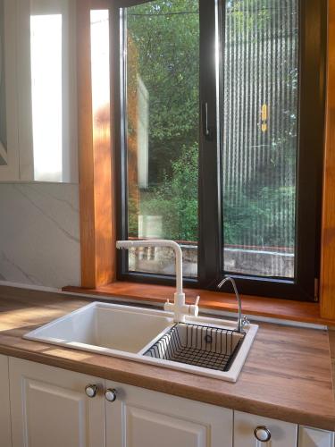 a sink in a kitchen with a window at GrapeHill Cottage in Achʼqva