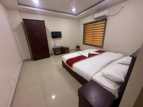 a bedroom with a bed and a television in it at Staio Rooms in Thodupuzha