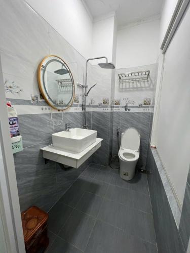 a bathroom with a sink and a toilet and a mirror at Lya Homestay CMT8 Da Nang in Danang