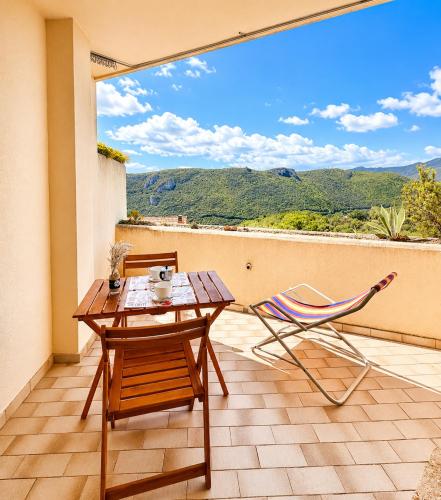 a patio with a table and a chair on a balcony at Hostdomus - Phil House in Finale Ligure