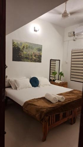 a bedroom with a large bed with two towels on it at Purayilhomestay in Varkala